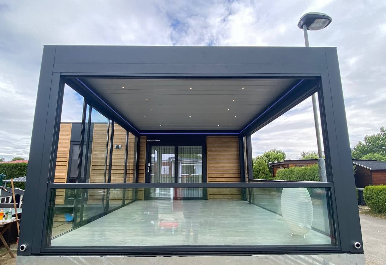 Glass-enclosed pavilion with louvered roof