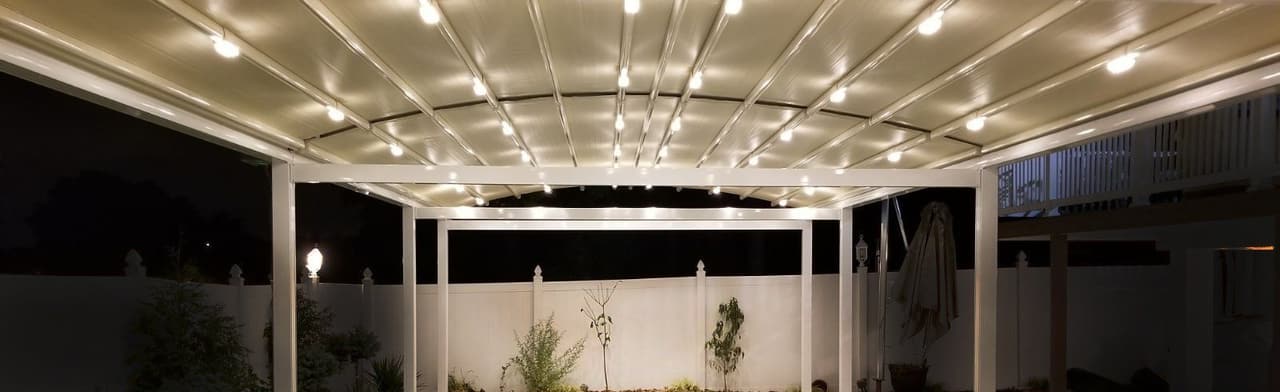 Pool deck covered by a lit retractable roof