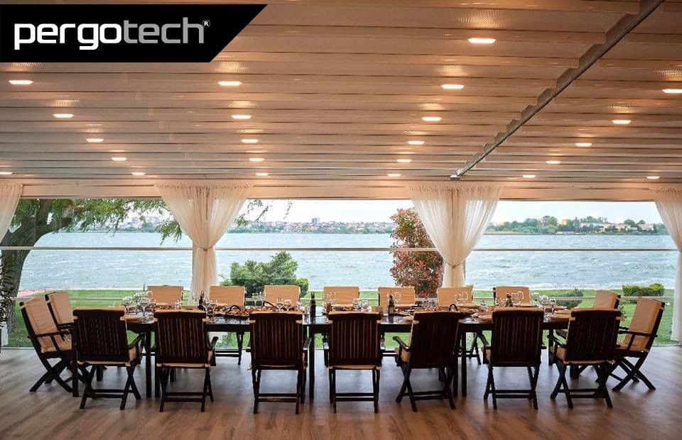 Sea-view dining room under a lit retractable roof